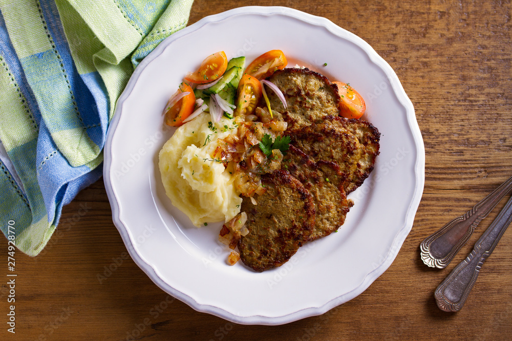 Beef liver pancakes with mashed potato and vegetables. Liver side dish. View from above, top studio shot