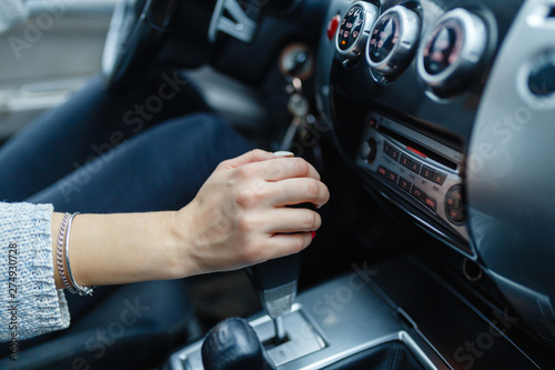 Woman switches the automatic transmission's close-up. Close-up of the driver's adm includes mode Drive on the gear lever automatic transmission of the car interior parts © korchemkin