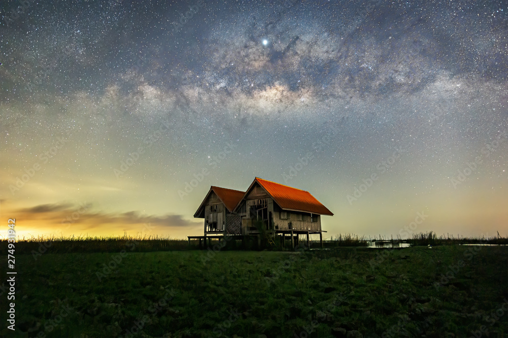 Milky Way , old abandoned house, red roof on open field