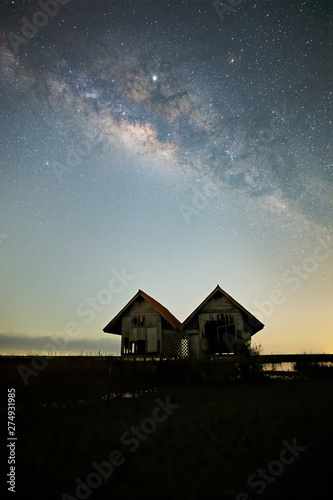 Milky Way , old abandoned house, red roof on open field