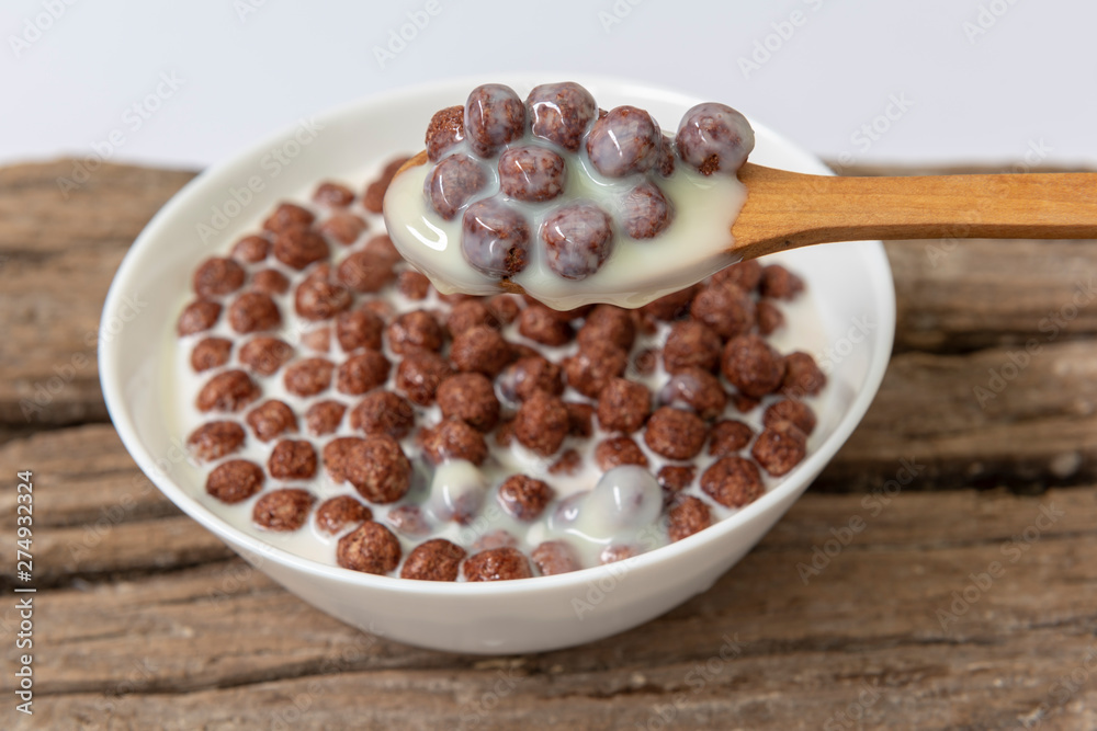 Un bol de leche con bolas de cereal de chocolate Photos | Adobe Stock