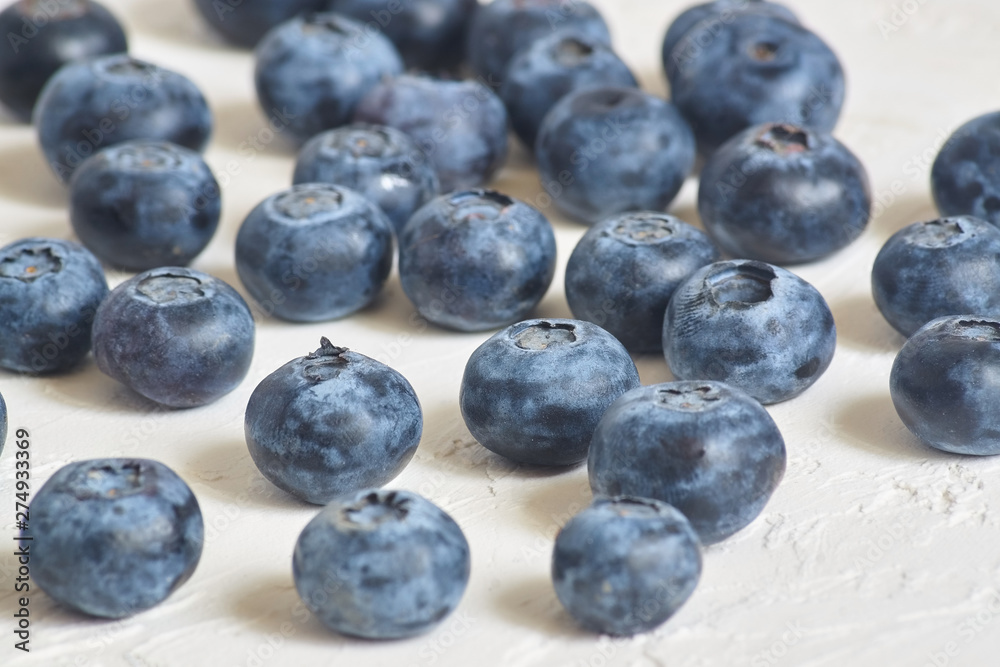 close up of blueberries on white concrete background close up of blueberries on white concrete background