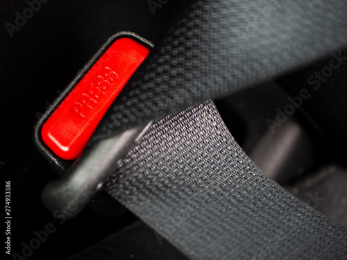Close up of the word press on a button of a Seat belt on black car seat