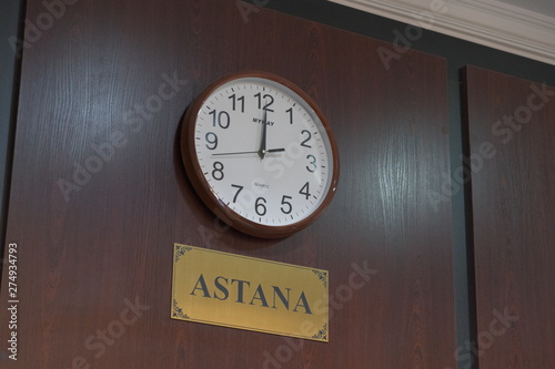 round clock hanging on the wall showing time in the city of Astana photo