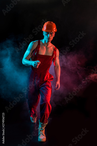 full length view of sexy shirtless fireman in overall, hardhat and protective goggles in smoke on black © LIGHTFIELD STUDIOS