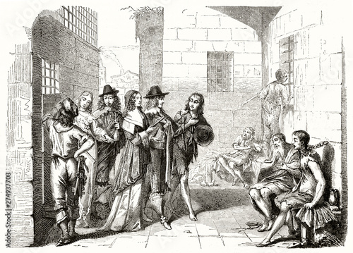 Foto Ancient aristocratic men visiting the interior of a shabby prison and its poor chained prisoners
