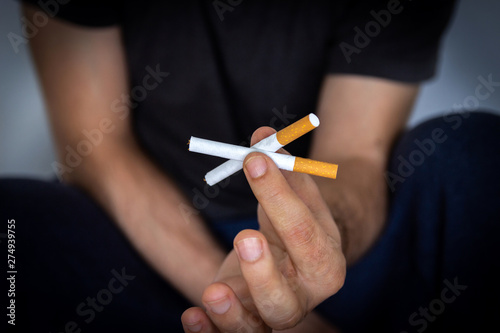 Man holding a cigarette, closeup cigarette and hand. Bad habits.