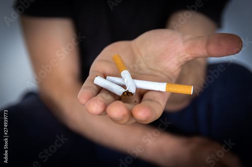 Man holding a cigarette, closeup cigarette and hand. Bad habits.