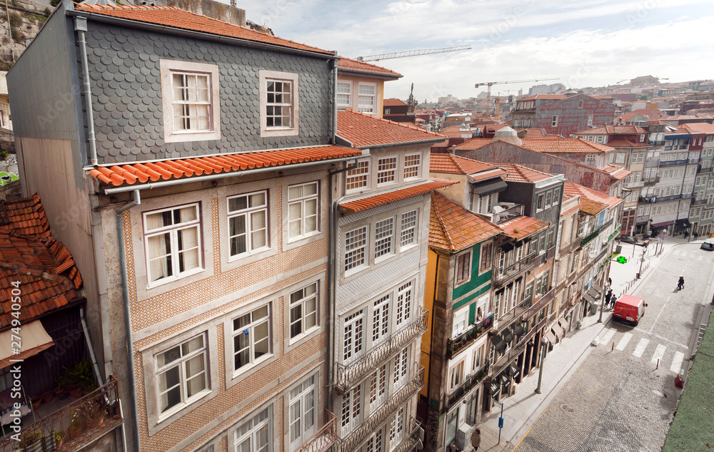 Cityscape of Porto from top floor, streets with historical buildings, tile roofs and colorful walls