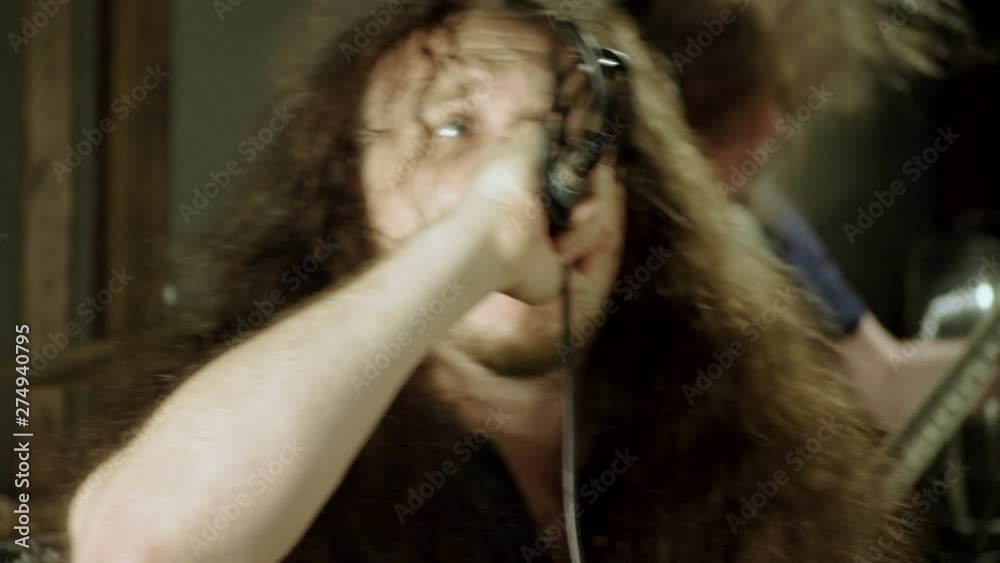 Musical metal band. Man singing a song into microphone, having performance with rock band in studio. 4K Musical metal band. Man singing a song into microphone, having performance with rock band in studio. 4K