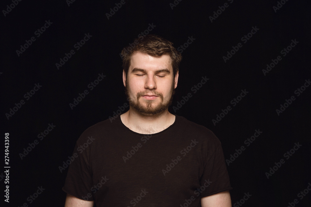 Close up portrait of young man isolated on black studio background. Photoshot of real emotions of male model with closed eyes. Thoughtful. Facial expression, human nature and emotions concept.