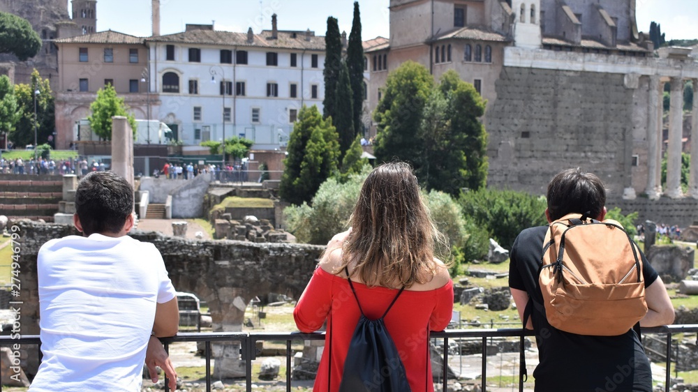 Young people observing an area of historical ruins in a tourist spot