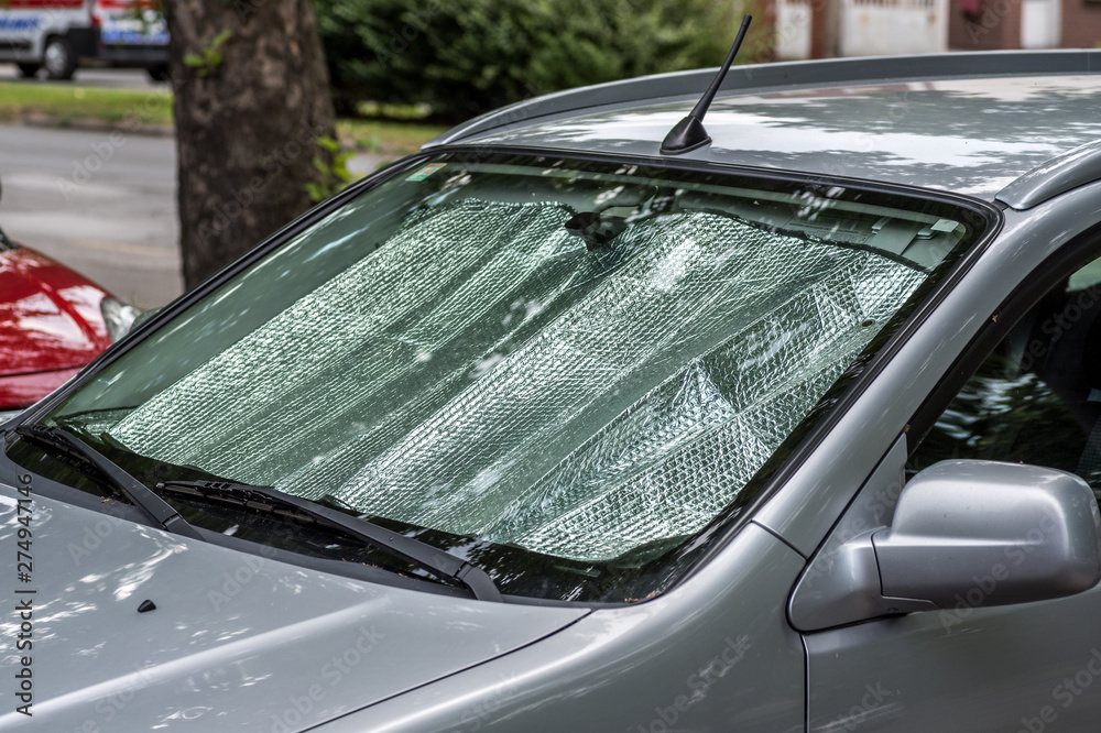 Sun reflector on the windscreen or windshield as protection of the car  plastic indoor panel from direct sunlight and heat Stock Photo | Adobe Stock