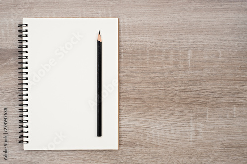 Top view, blank book and pencil on blank book on the wooden table.