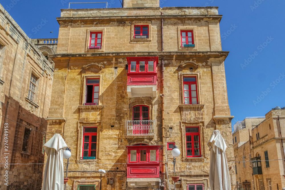 Building with traditional red maltese balcony in Valletta, Malta