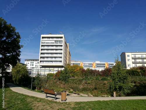 Parkanlage mit Bank für Spaziergänger und modernes Hochhaus des Klinikum Lippe Detmold vor blauem Himmel im Sonnenschein in Detmold asm Teutoburger Wald in Ostwestfalen-Lippe photo