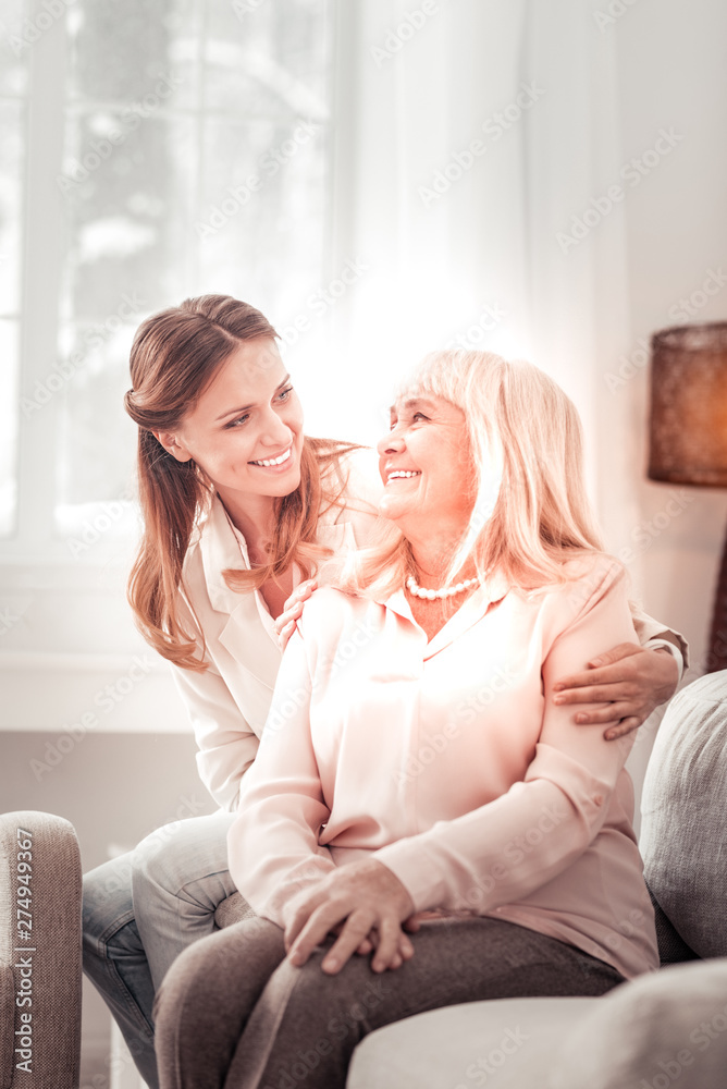 Obraz premium Beautiful mother and daughter smiling happily to each other
