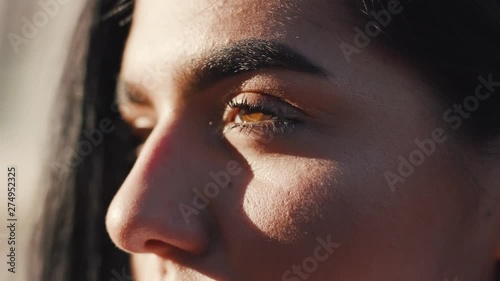 Close up of young Caucasian woman's eyes blinking. Extreme close-up of pretty brown eyes with long lashes. Natural beauty, bright sunshine