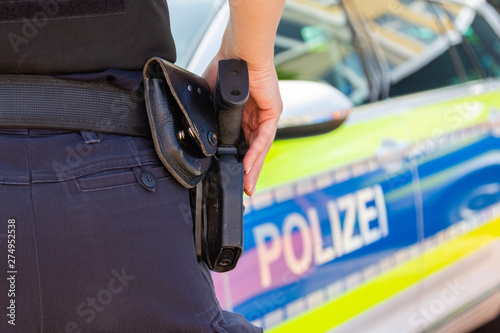 Female police officer keeps her hand on her weapon. Polizei is the german word for police