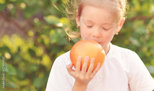 girl in nature with grapefruit, orange fruit