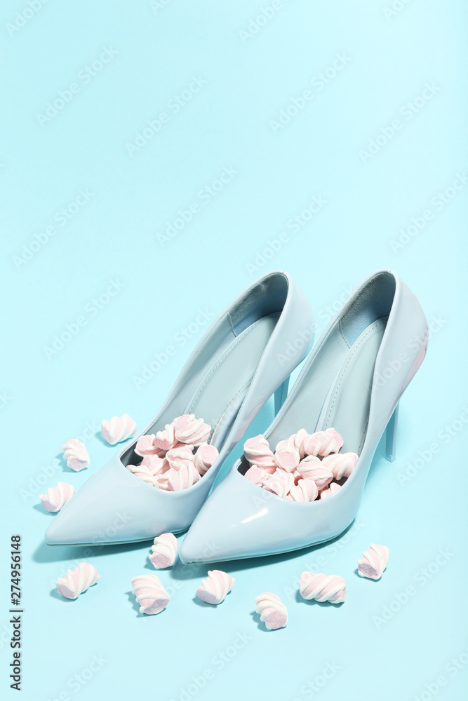 High heeled shoes with marshmallows on blue background. Minimalism concept