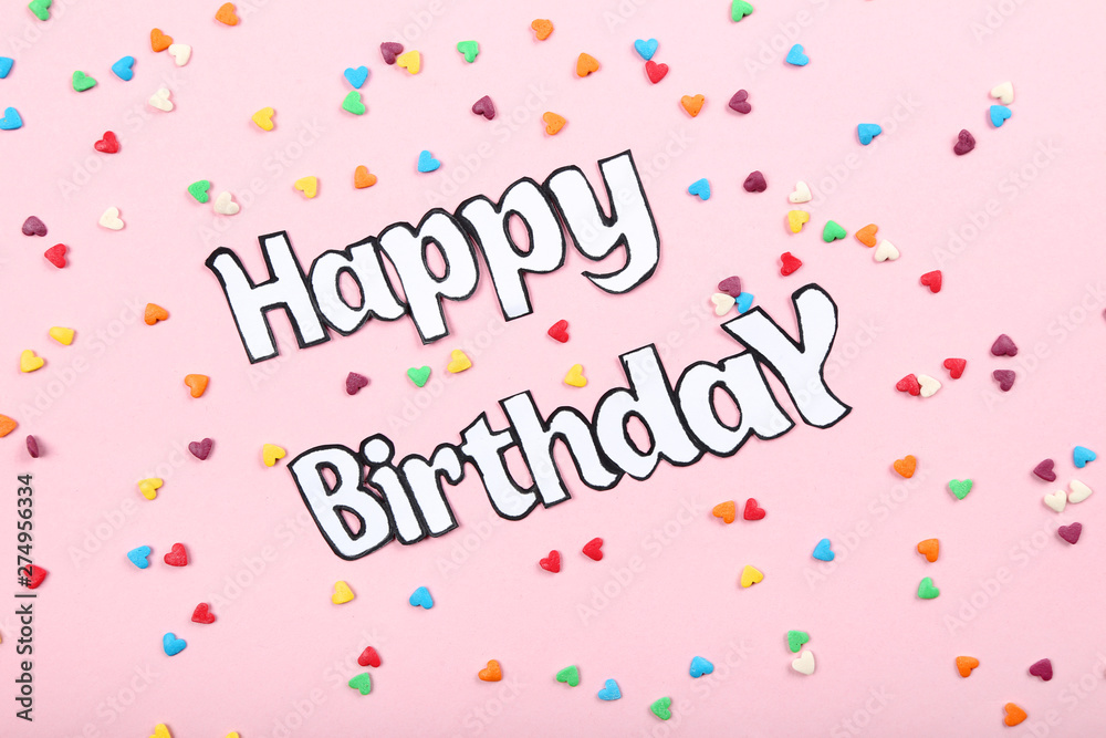 Text Happy Birthday with colorful sprinkles on pink background