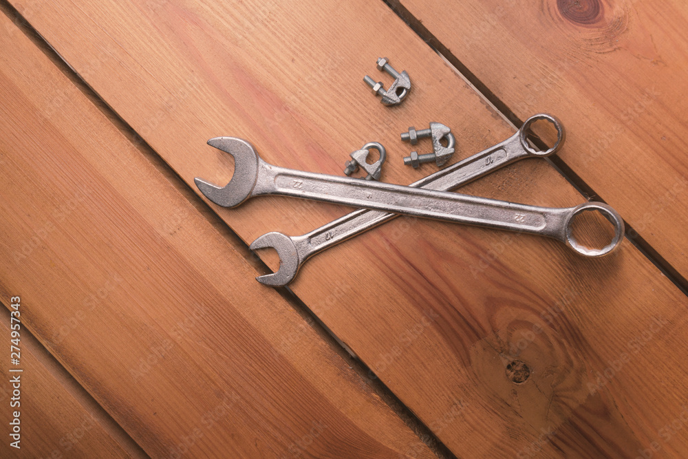 Two wrenches and some bolts are laying on a wooden surface Two wrenches and some bolts are laying on a wooden surface
