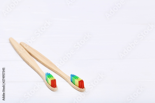 Bamboo toothbrushes on white wooden table