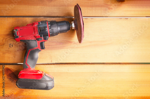 One power tool with a sander is laying on a wooden surface
