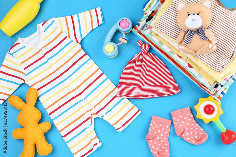Baby clothes with toys on blue background