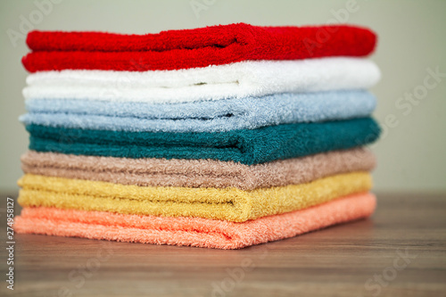 Stack colorful towels in bathroom on table