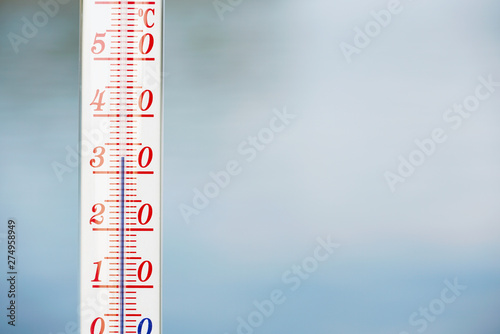 Thermometer during hot weather with water in background