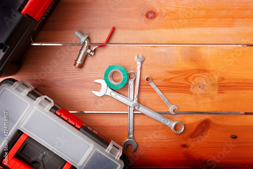 A set of tools and two tool boxes are laying on a wooden surface