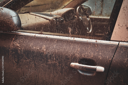 Closeup photo shoot of dirty car's door and window, splash of mud on silver car.