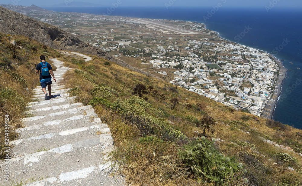 The village of Kamari in the island of Santorini, Greece, seen from way above at the entrance of the Ancient Village of Thera in a bright sunny day.