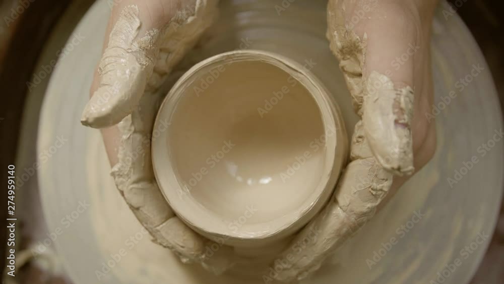 close-up of a Potter's hand sculpts a pot pitcher of clay on a Potter's wheel close-up of a Potter's hand sculpts a pot pitcher of clay on a Potter's wheel