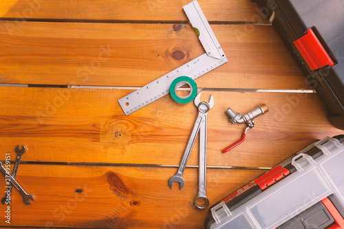 A set of tools and two tool boxes are laying on a wooden surface