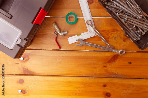 A set of tools and two tool boxes are laying on a wooden surface