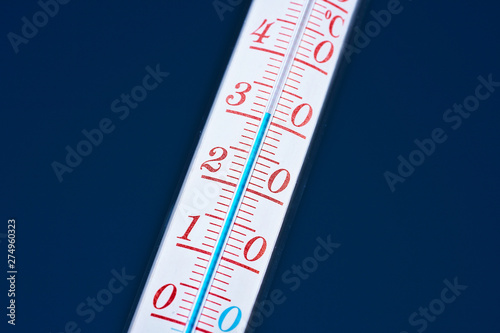 Thermometer during hot weather with sky in background