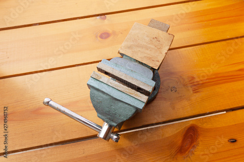 A blue vice is laying on a wooden surface