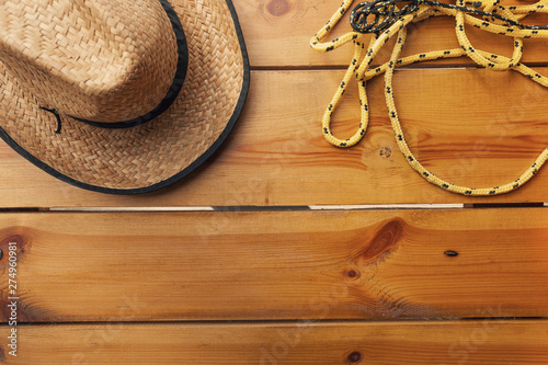 A wicker hat and rope are laying on a wooden surface