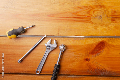A various assortment of tools is laying on a wooden surface