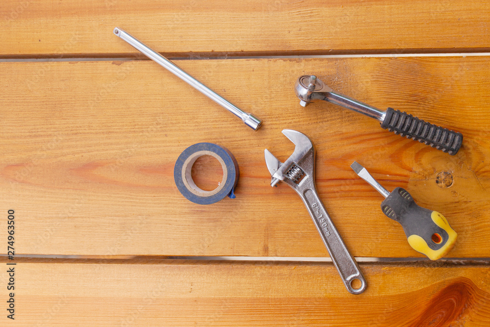 A various assortment of tools is laying on a wooden surface A various assortment of tools is laying on a wooden surface