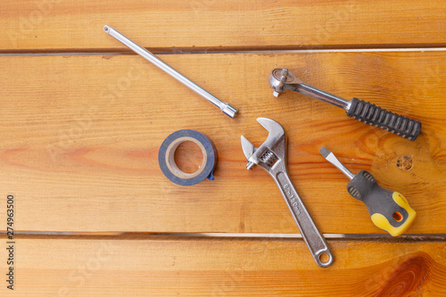 A various assortment of tools is laying on a wooden surface