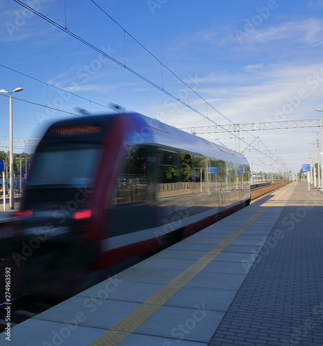 train in motion, in soft focus, leaves platform