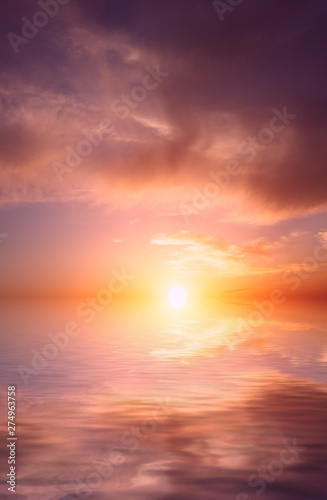 The bright orange sun rises against the backdrop of purple clouds and a calm sea. © Sviatoslav Khomiakov