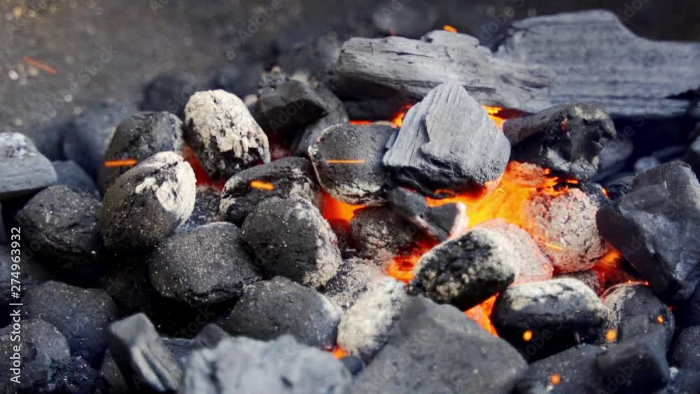 Closeup of glowing coal in metal grill on summer day in slow motion Closeup of glowing coal in metal grill on summer day in slow motion