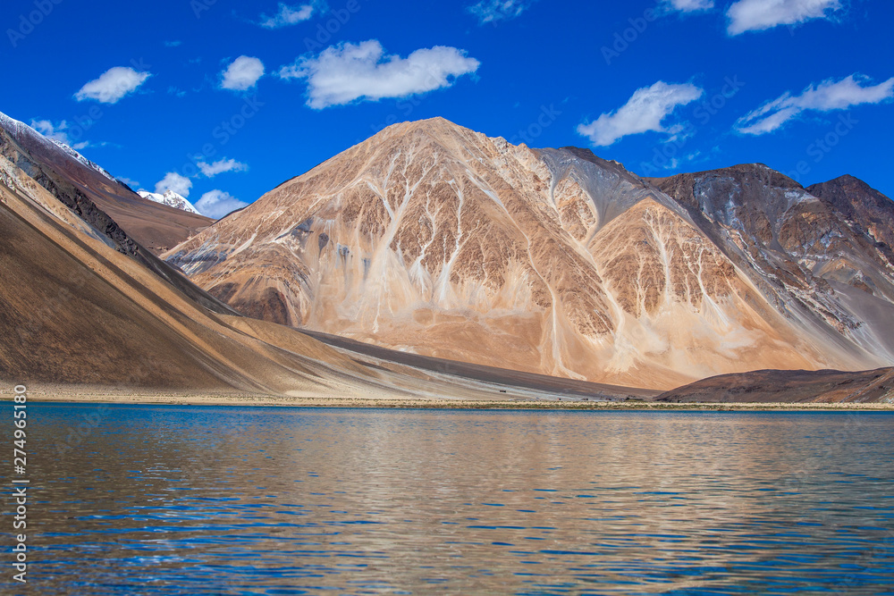 View of majestic rocky mountains against the blue sky and lake Pangong in Indian Himalayas, Ladakh region, India. Nature and travel concept View of majestic rocky mountains against the blue sky and lake Pangong in Indian Himalayas, Ladakh region, India. Nature and travel concept