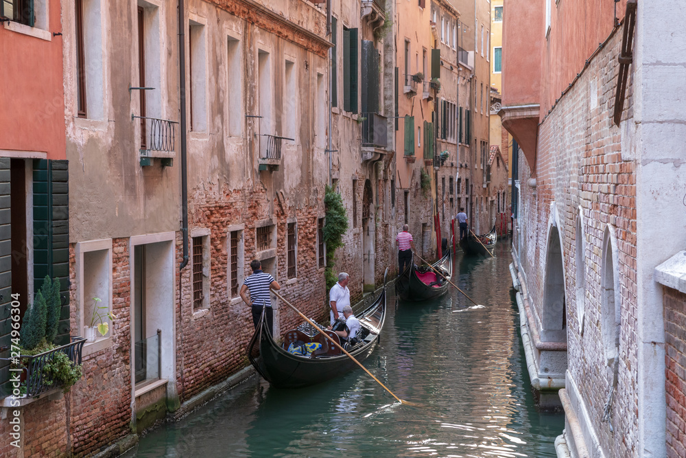 Panoramic view of Venice narrow canal with historical buildings and gondolas