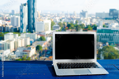 The computer is on the table near the panoramic window with a beautiful panoramic view